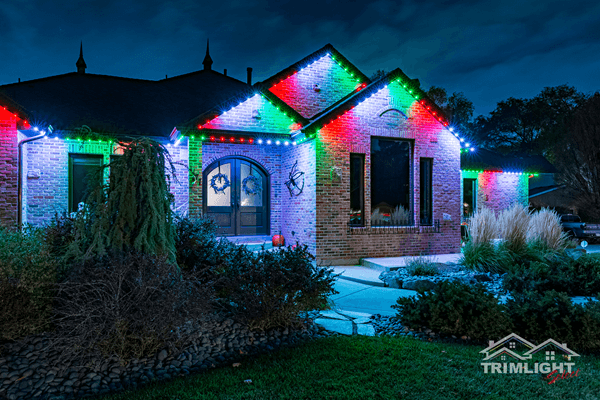 House decorated with colorful Christmas lights at night.